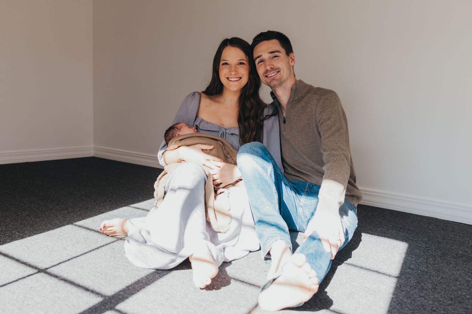 Family lounging together on carpeted floor in casual attire.