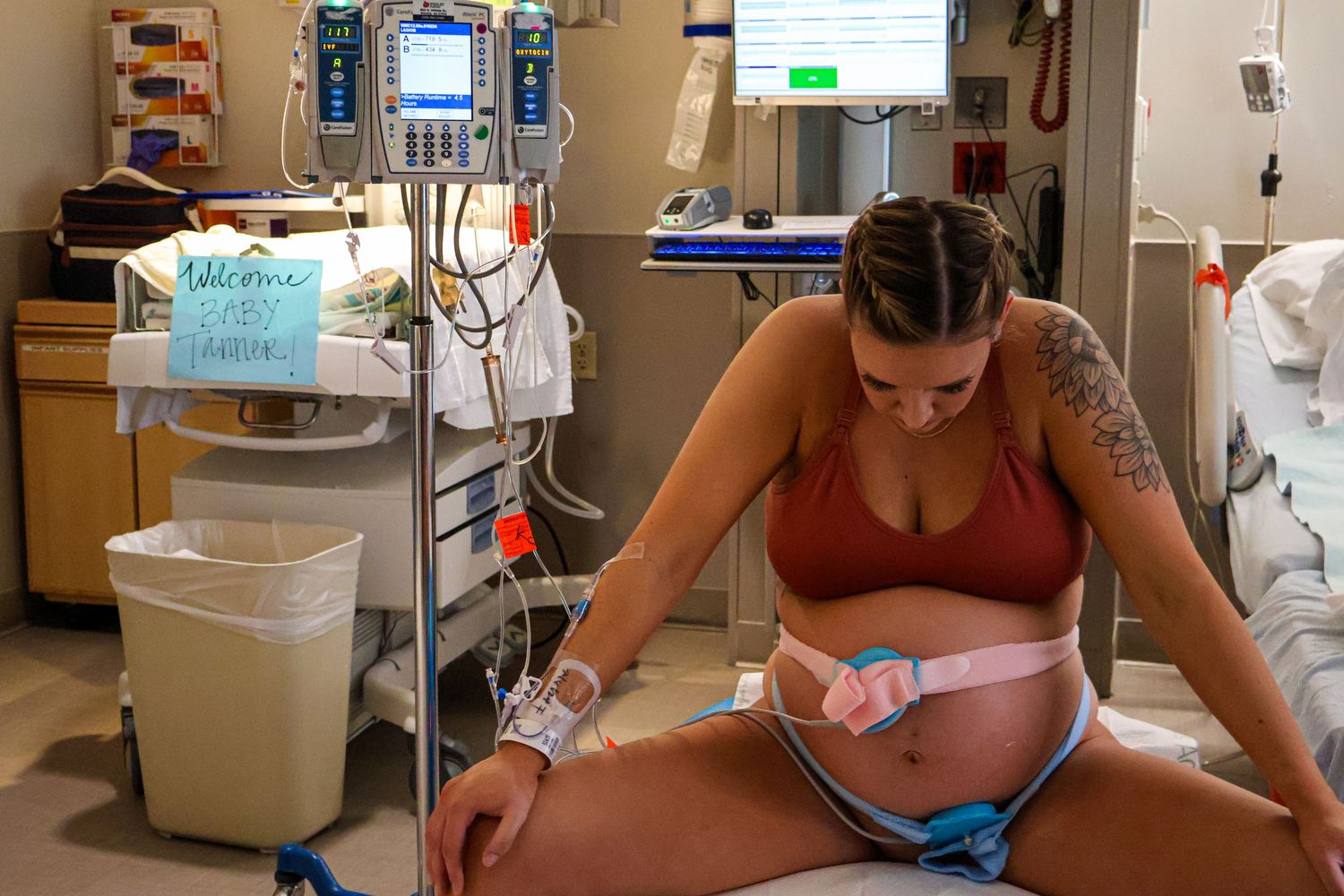 Medical equipment and monitors visible in hospital delivery room setting.