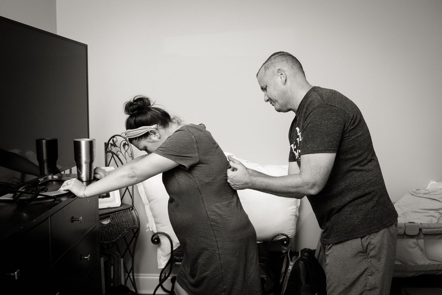 Black and white photographs capture movement and interaction in a minimalist bedroom setting.