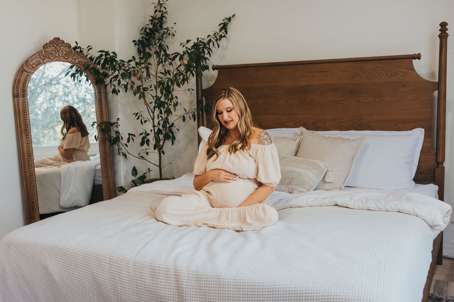 Intimate bedroom photoshoot with soft natural lighting and white bedding. Wichita, Kansas Maternity Photography