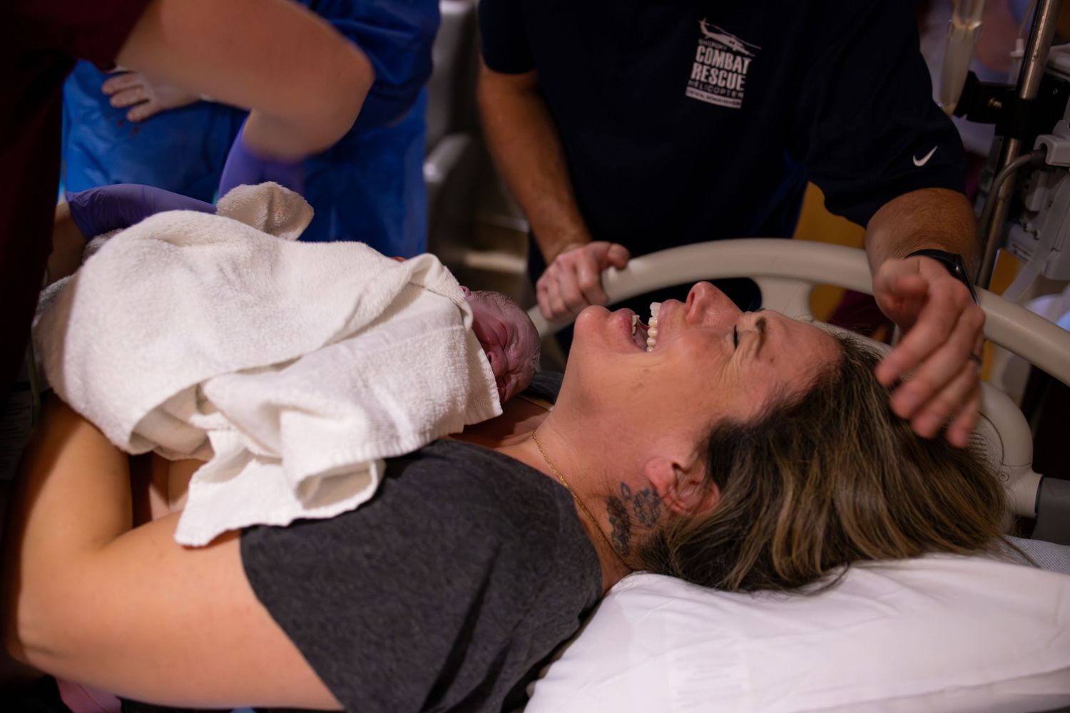 A person lies on a medical bed during what appears to be a labor and delivery experience.