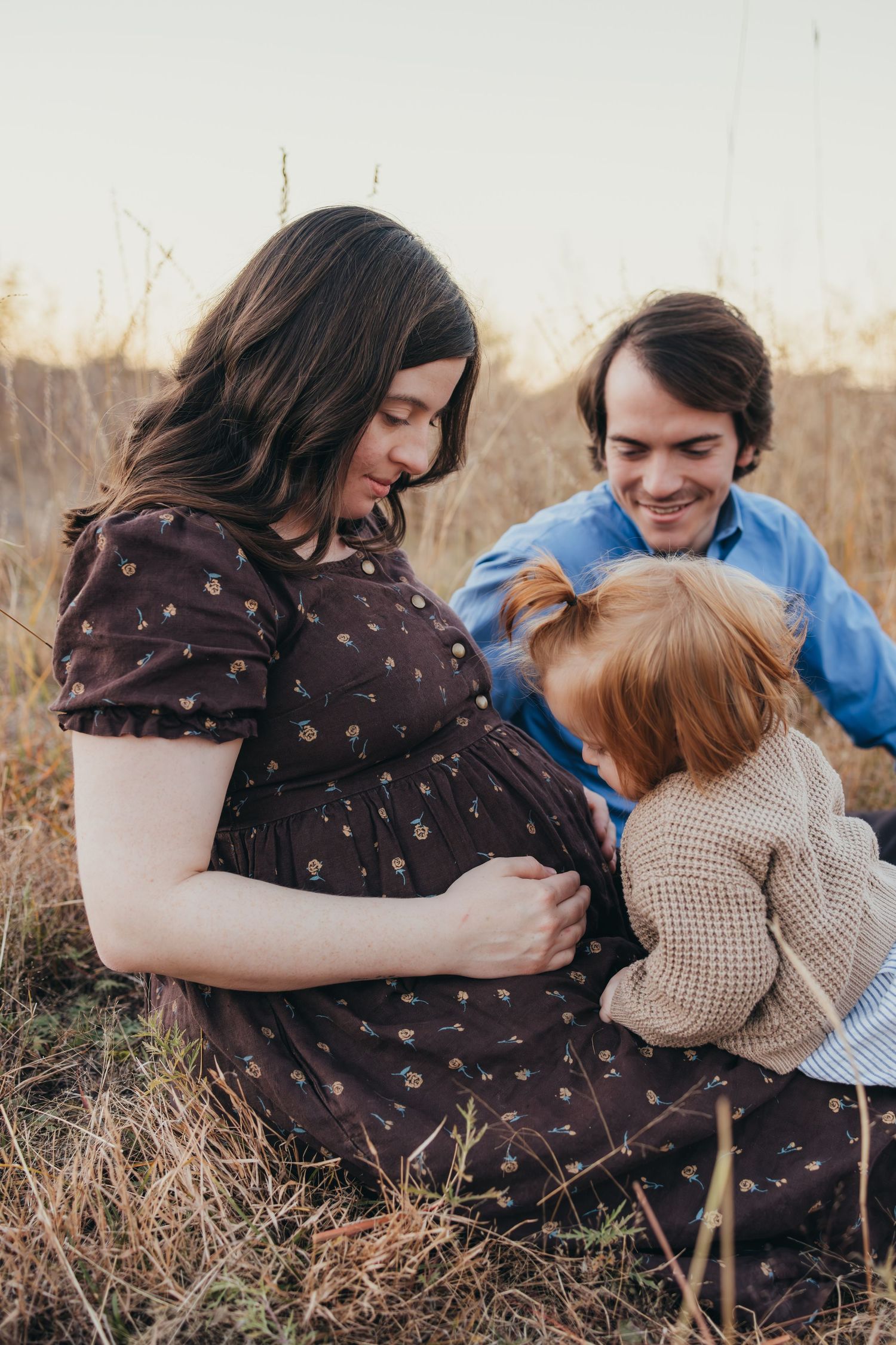 Couple cuddling on blanket in field during golden hour photoshoot. Wichita, Kansas Maternity Photography