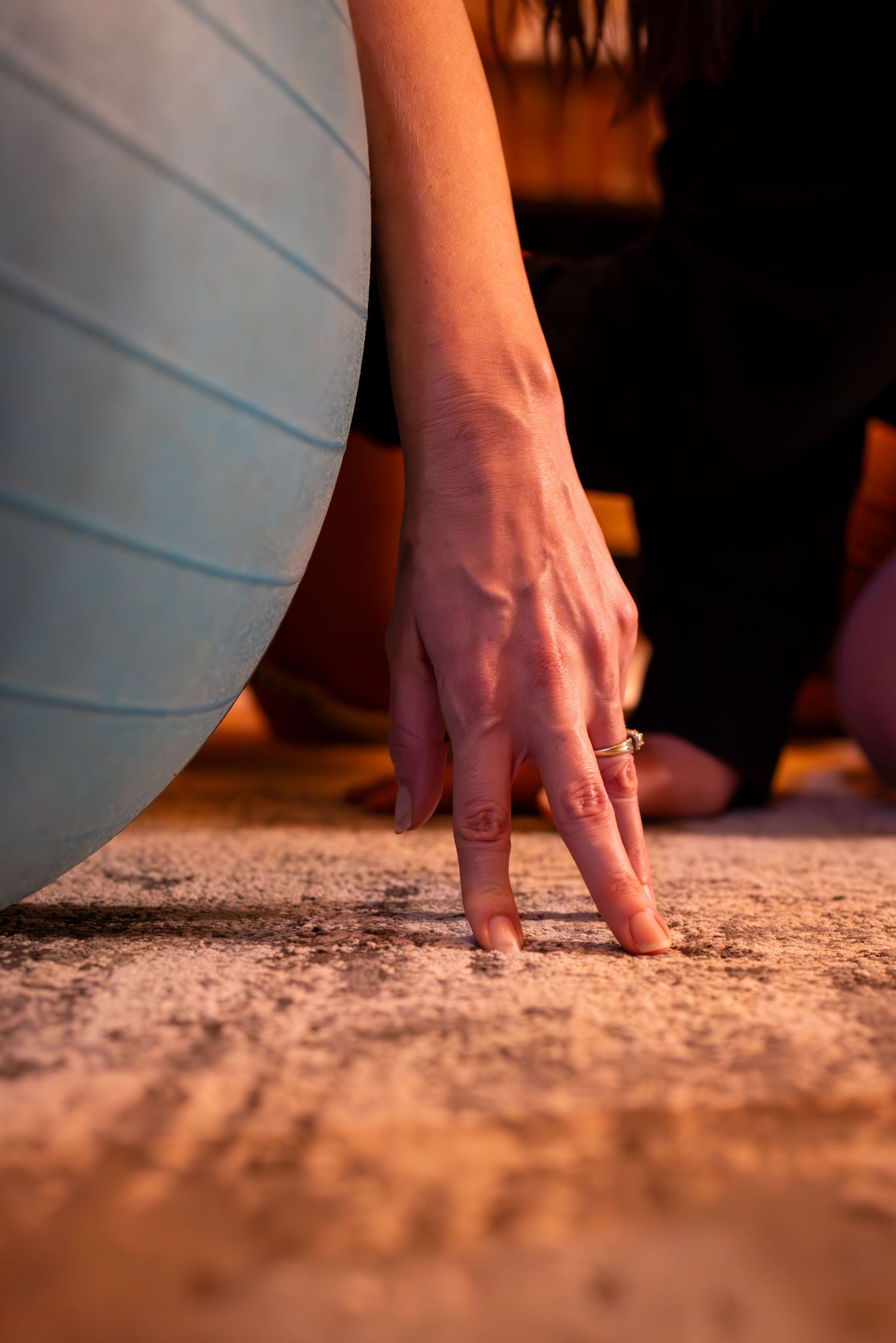 Close-up of a hand touching a textured carpet surface in warm lighting.