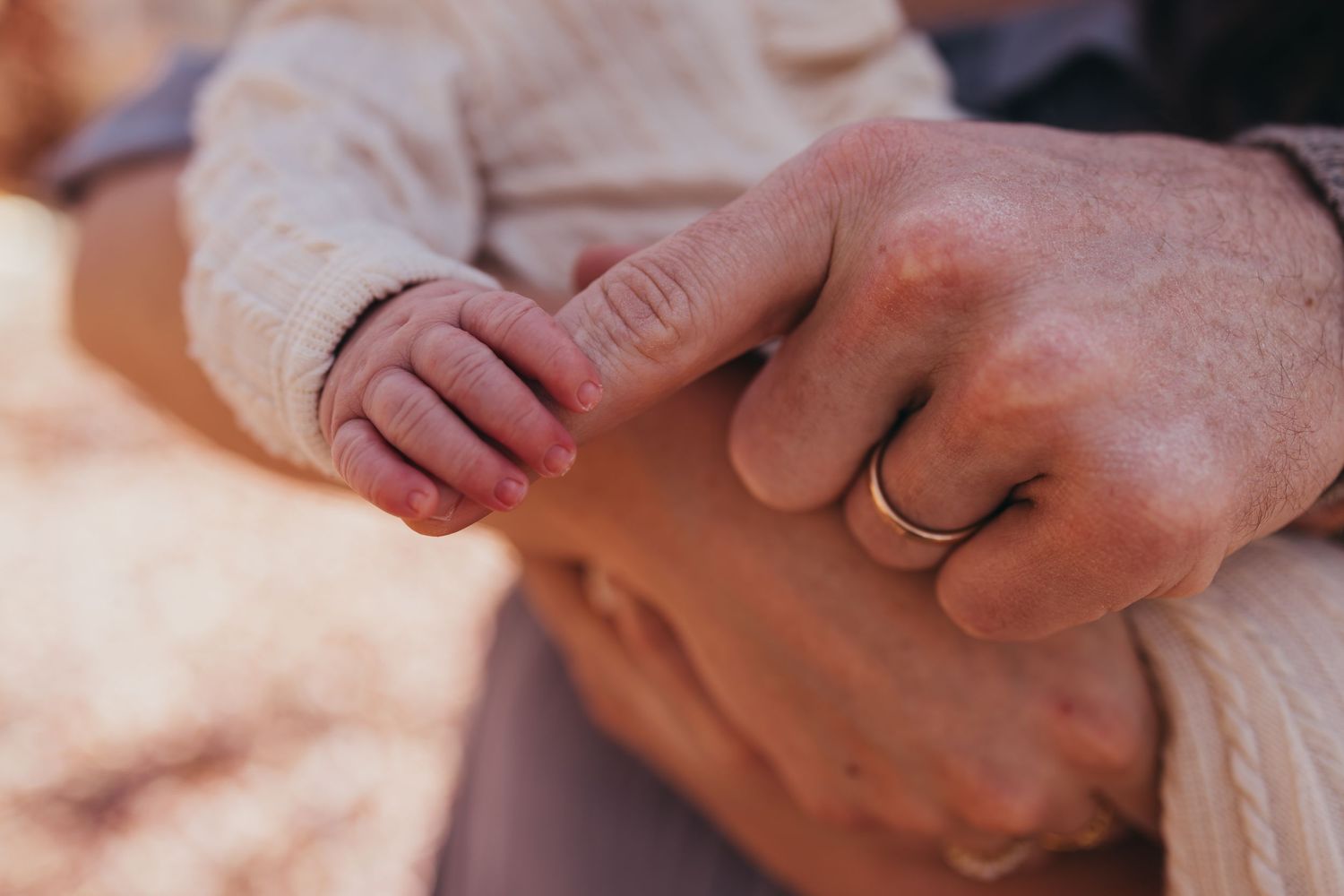 Gentle hands holding and caressing a newborn baby.