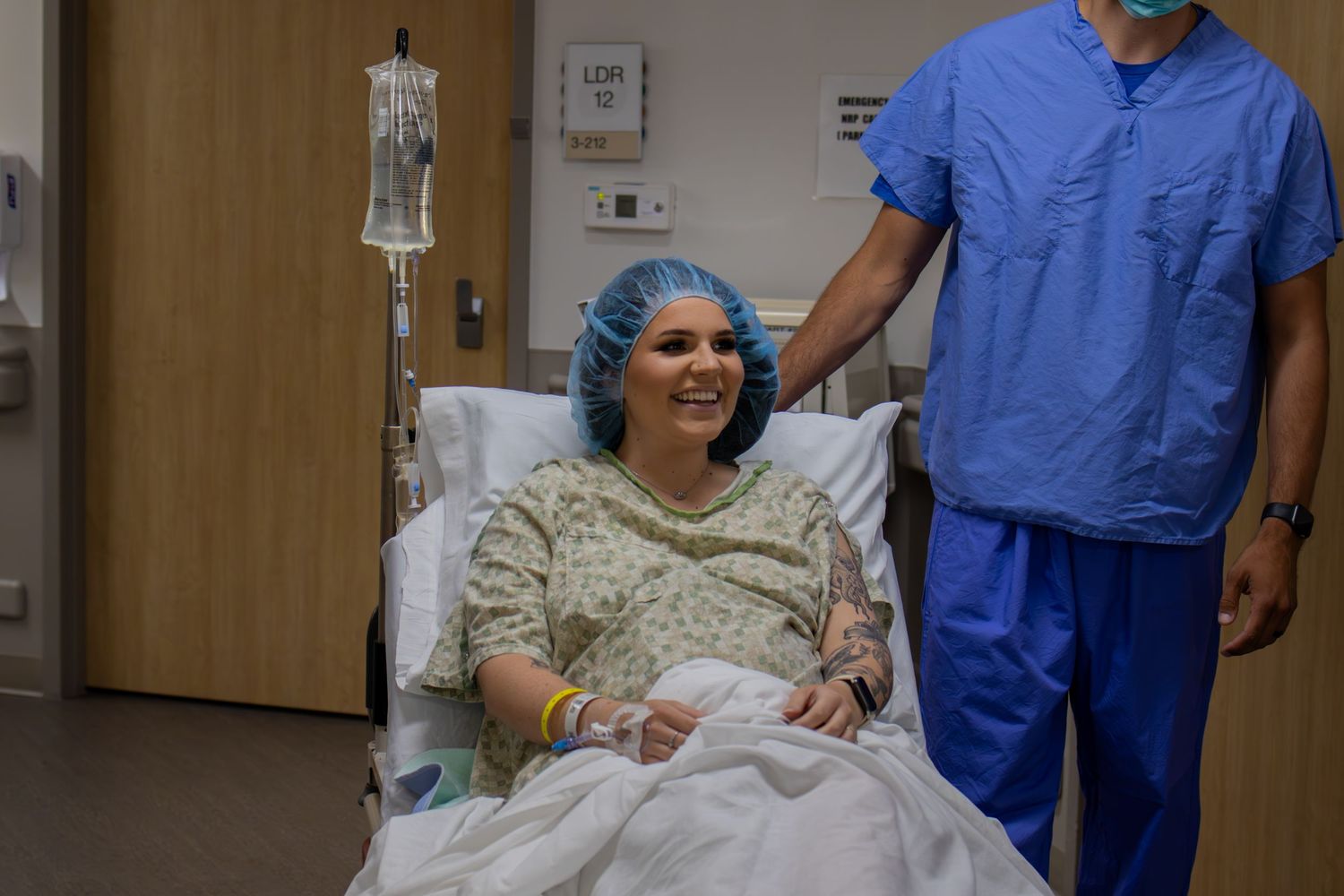 Healthcare workers providing care to patient in hospital room.