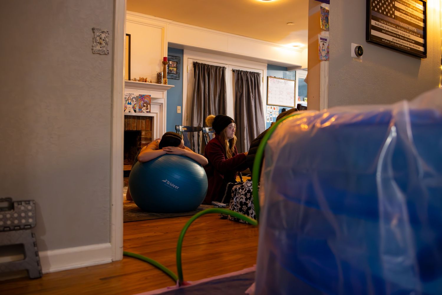 Interior view of a dimly lit room with laboring woman. Wichita birth photographer documenting a home birth