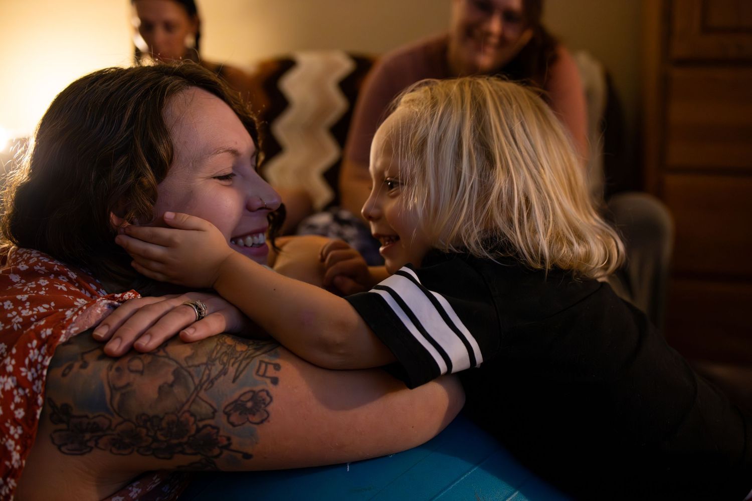 A tender moment of connection on a blue surface with warm lighting.