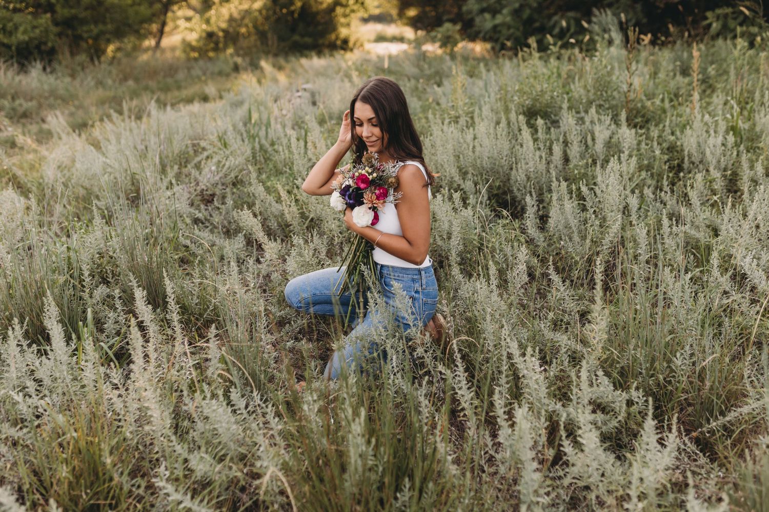 Someone photographing in a field of sage brush during sunset.