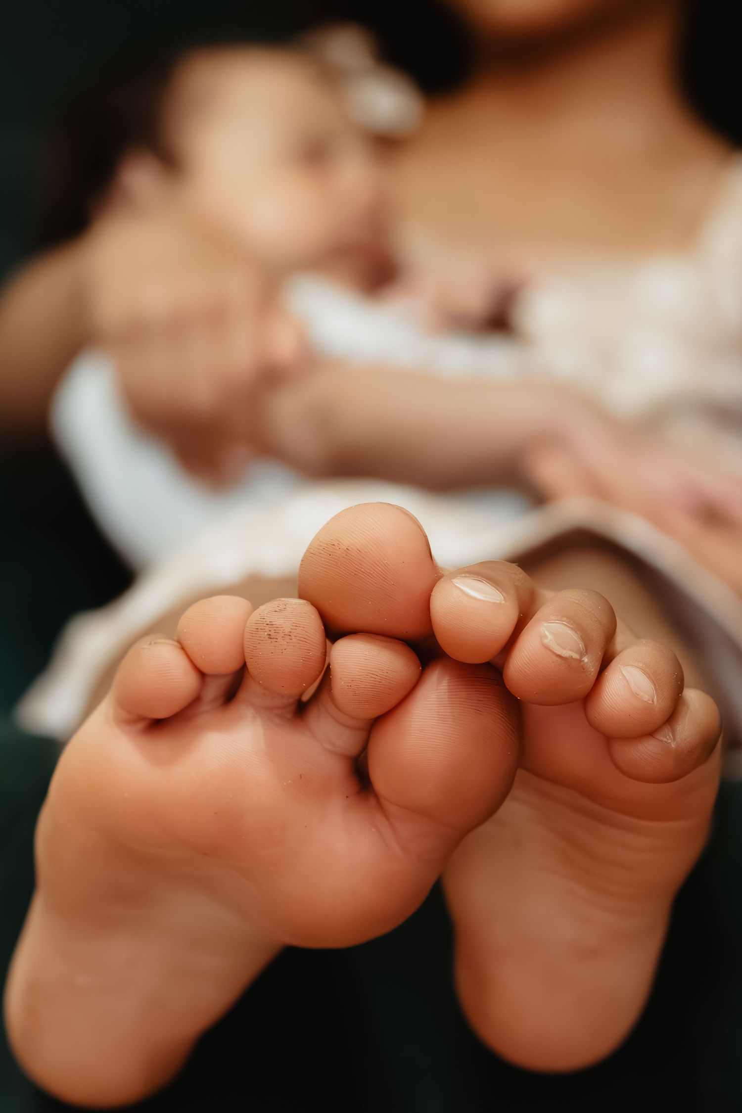 Close-up view of tiny baby toes against a dark background.