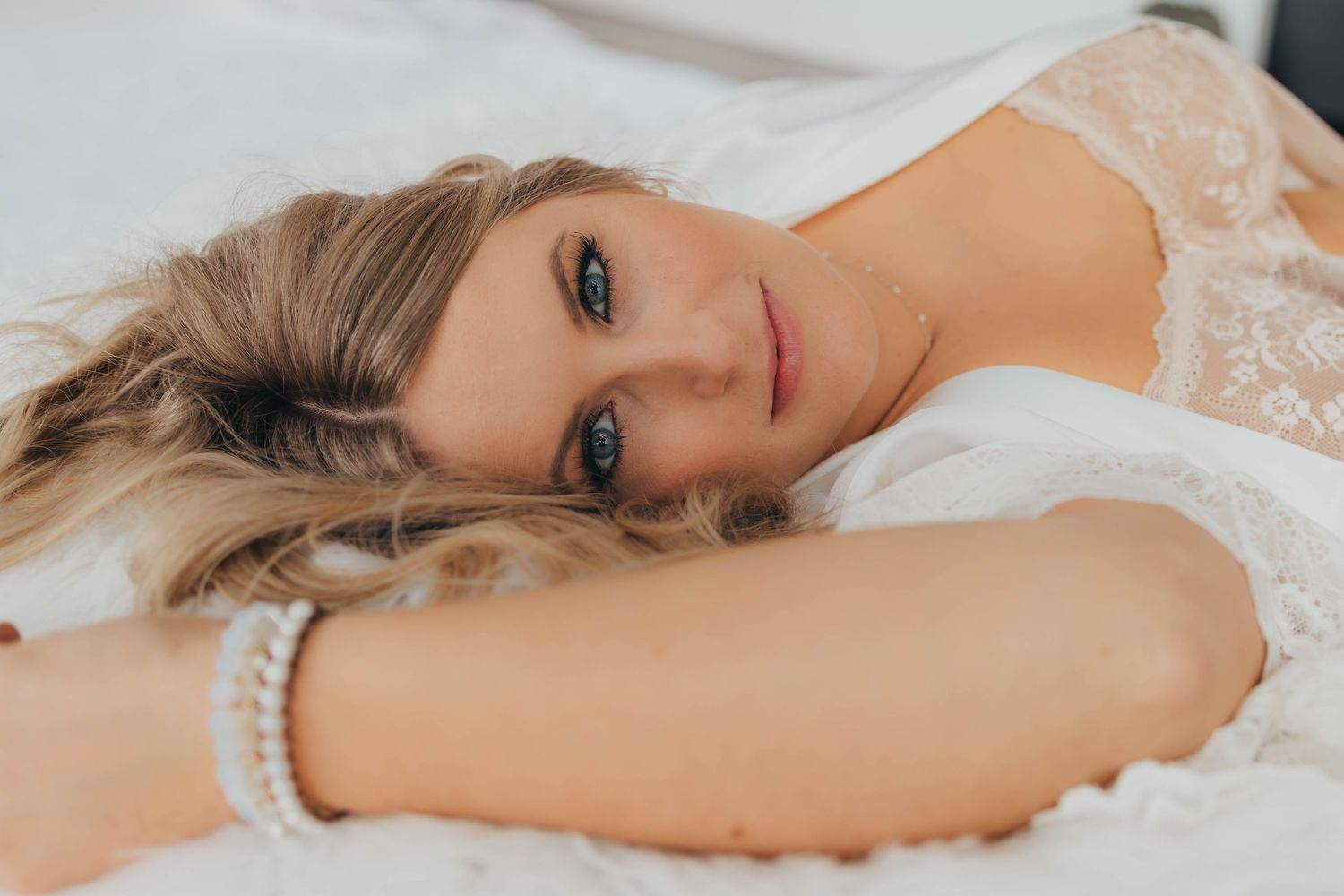 Intimate boudoir photography with soft natural lighting and delicate lace accents.