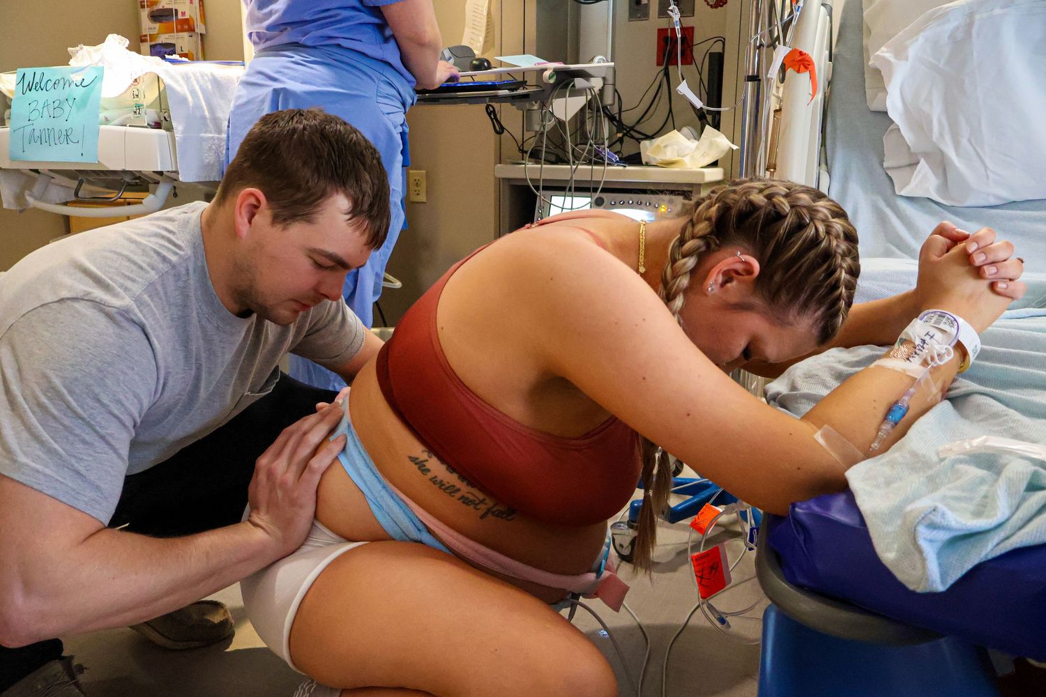 Healthcare providers assisting during childbirth in hospital delivery room.