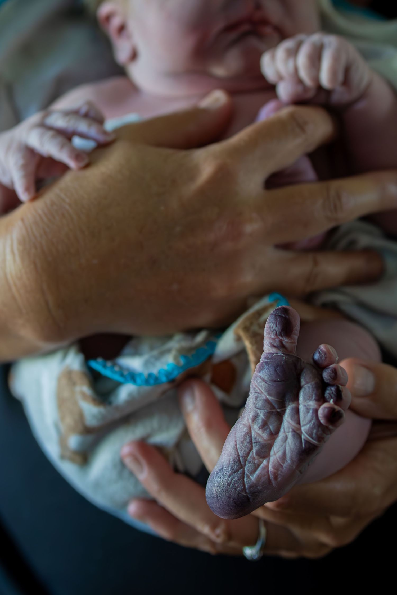 Close-up shots of hands holding and examining a newborn baby.
