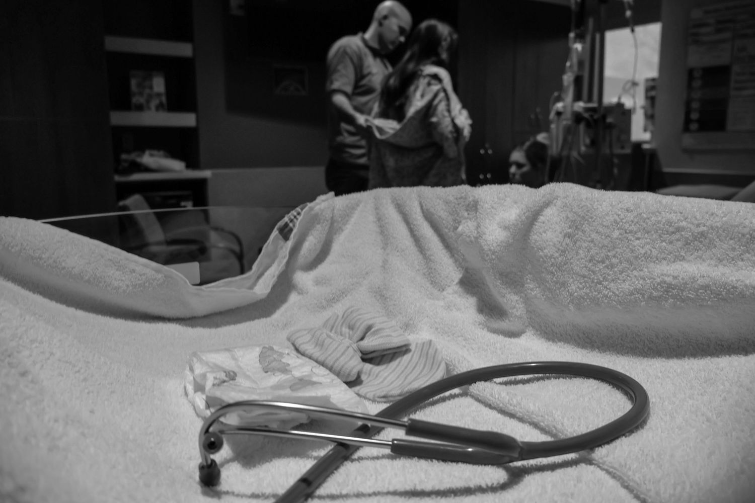Medical equipment and monitoring devices in a dimly lit hospital room.