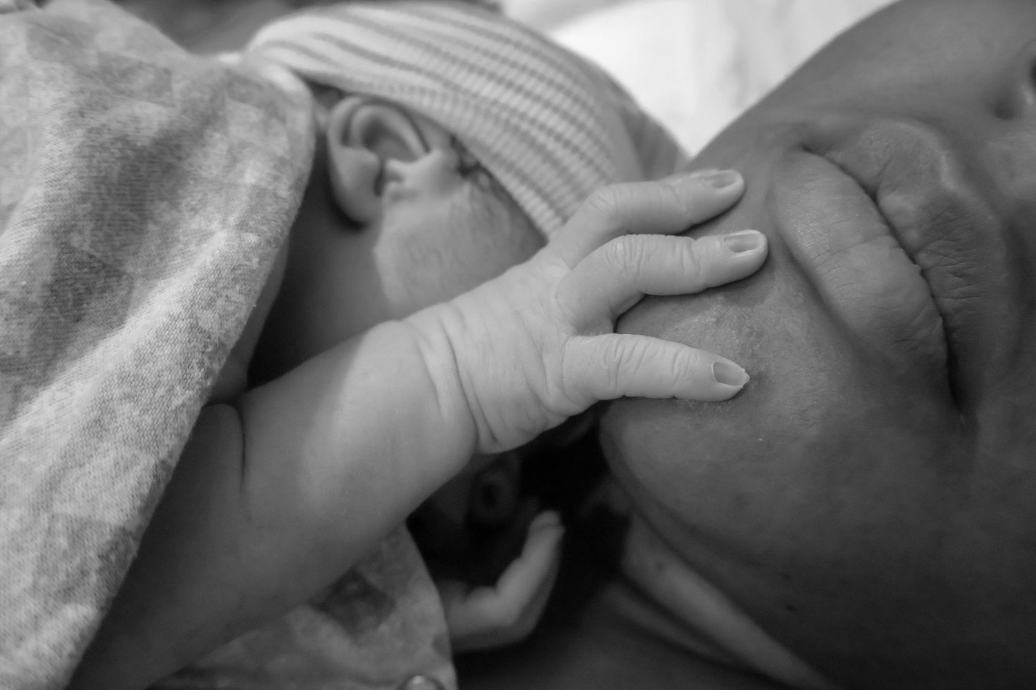 Close-up black and white image of gentle hands providing medical care.