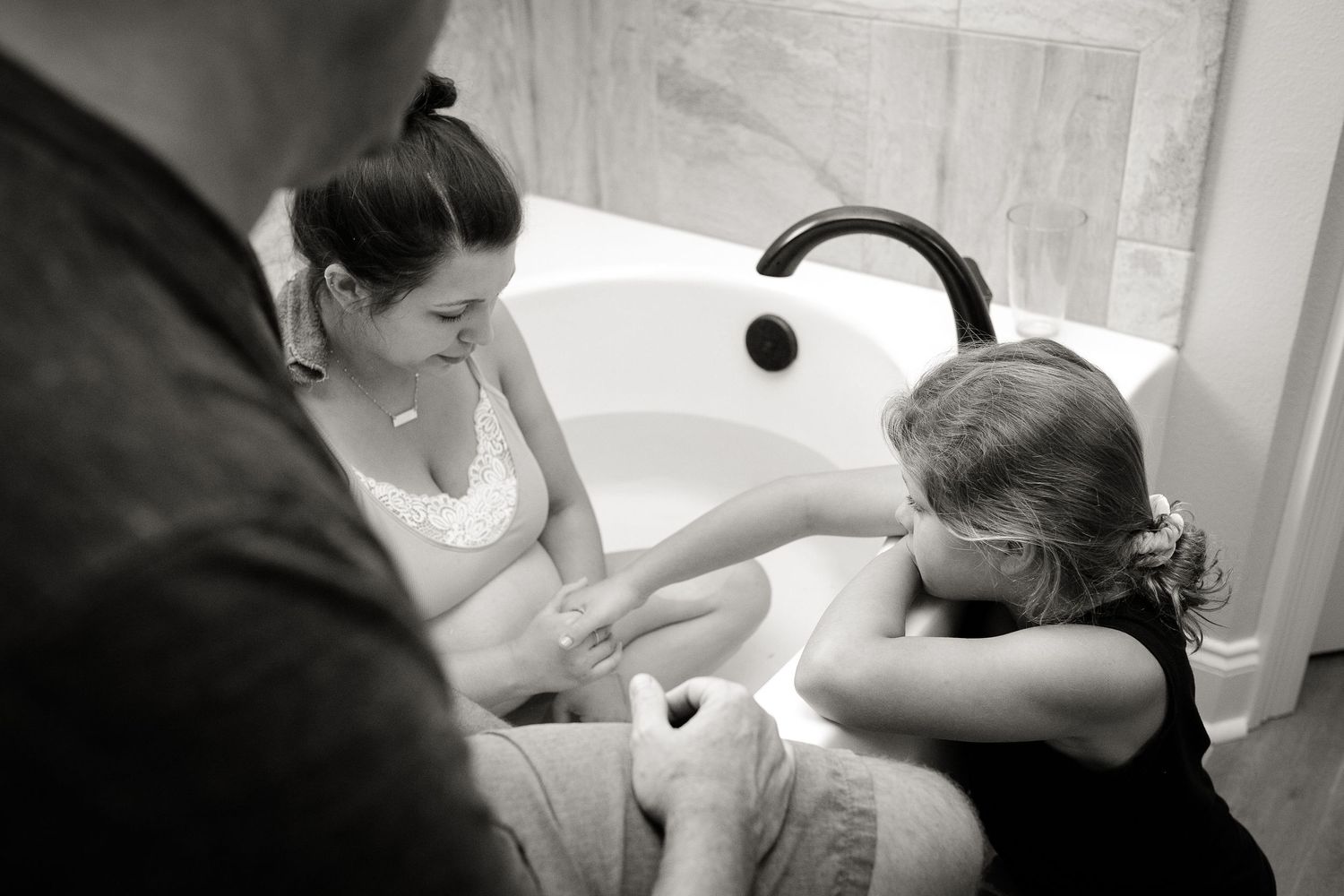 Serene bathtub scene with a pregnant woman resting during labor.