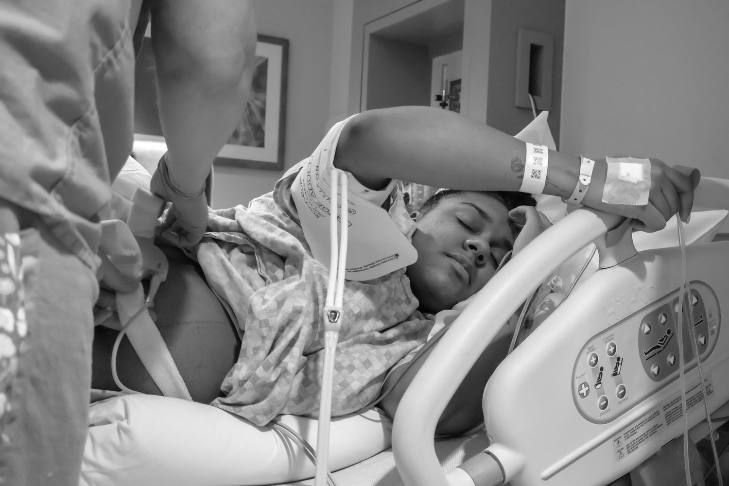 Black and white image of medical care being provided in a hospital setting.