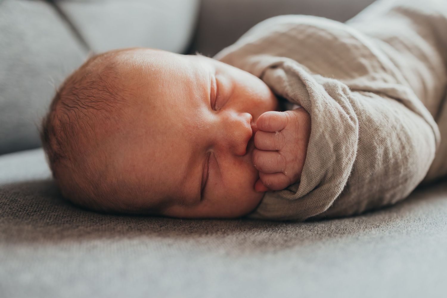 Series of minimalist black and white images showing different angles of a sleeping baby in soft fabric.