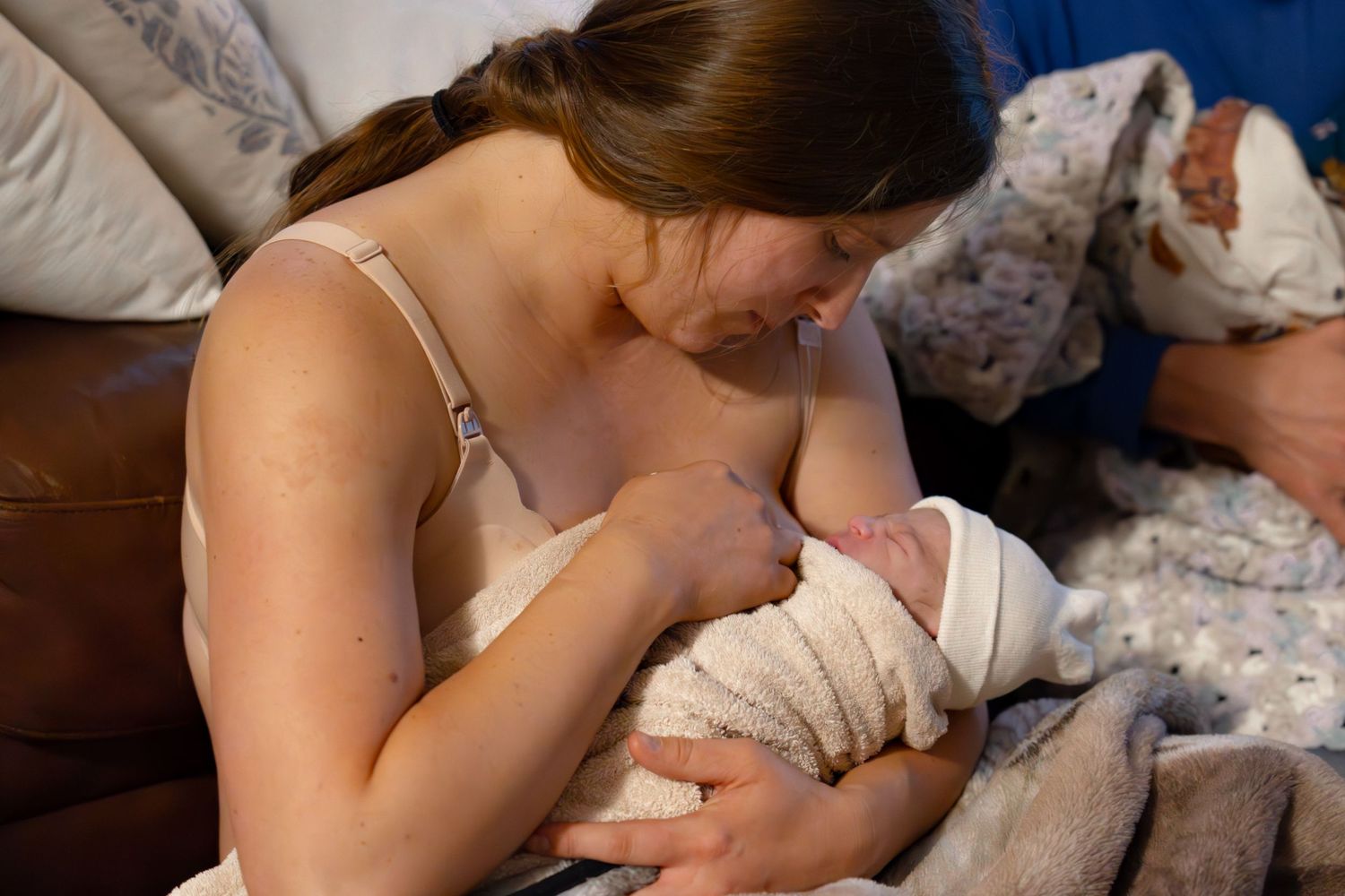 Mother labors in bed while receiving comfort measures during birth.