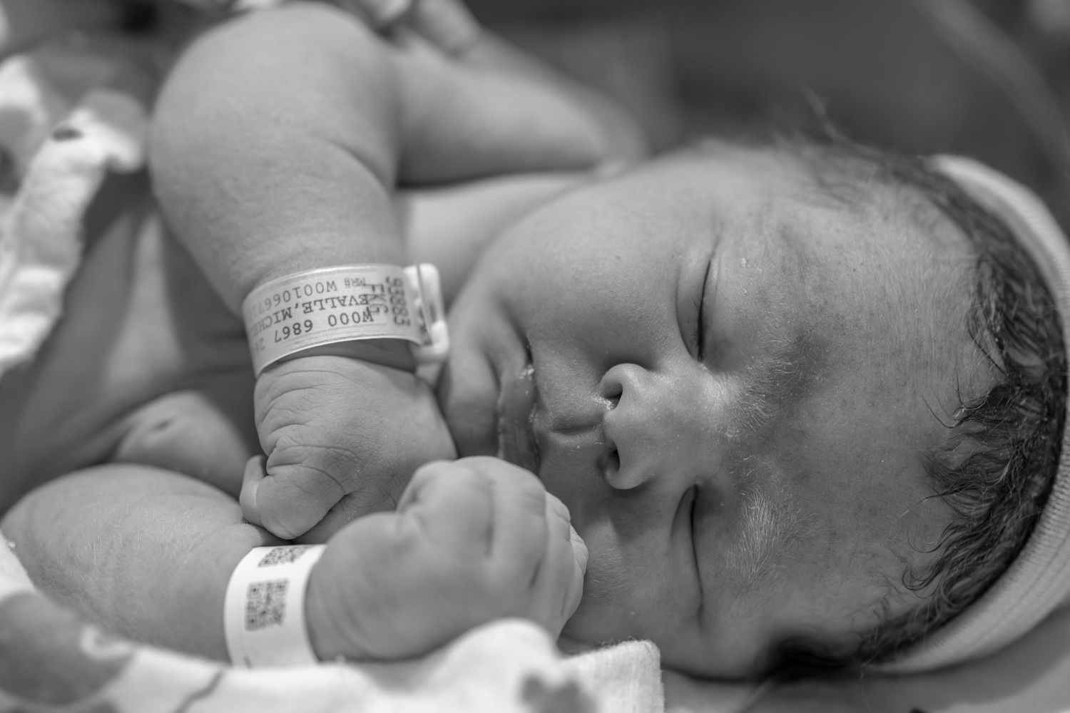 Newborn baby resting peacefully in a hospital setting.