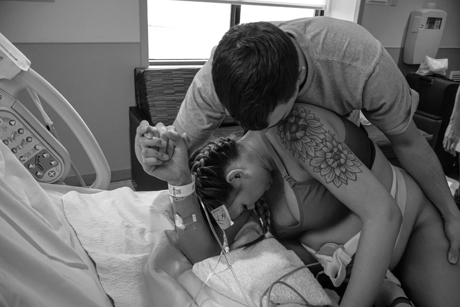 Series of black and white photographs capturing intimate moments during childbirth in a hospital setting.