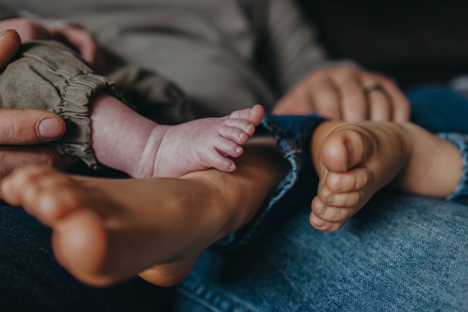 Close-up detail of bare feet resting on blue denim fabric.