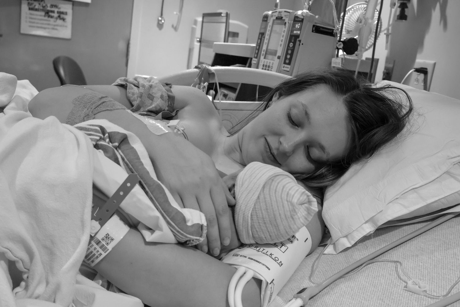 Hospital room scene in black and white showing medical equipment and patient care during labor.