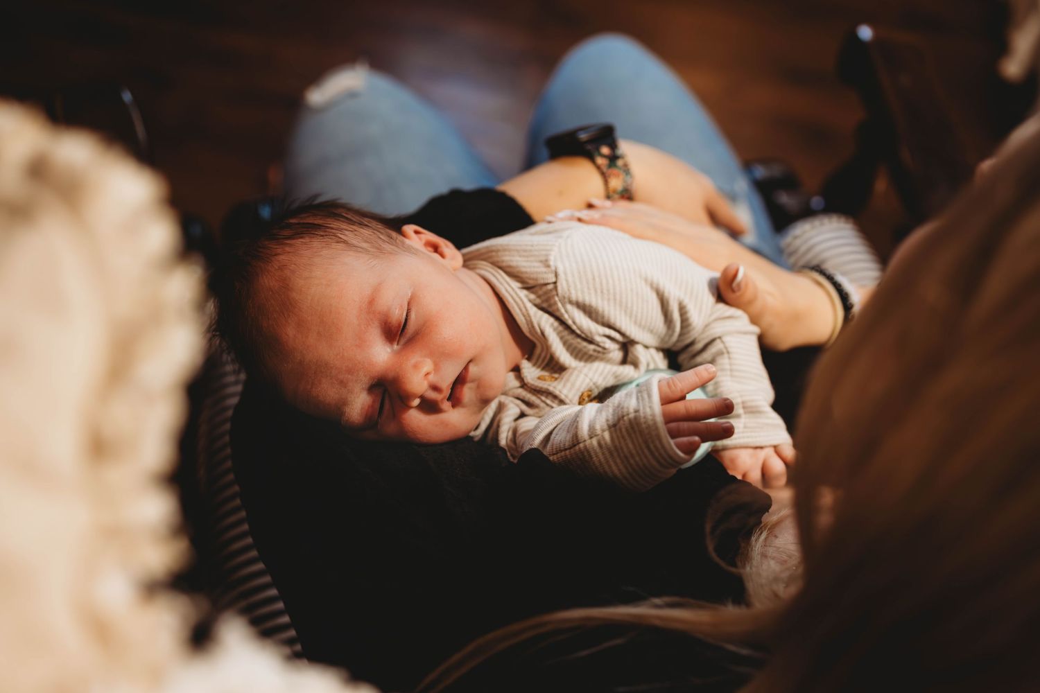 Baby sleeping peacefully in cozy nursery setting with warm lighting.