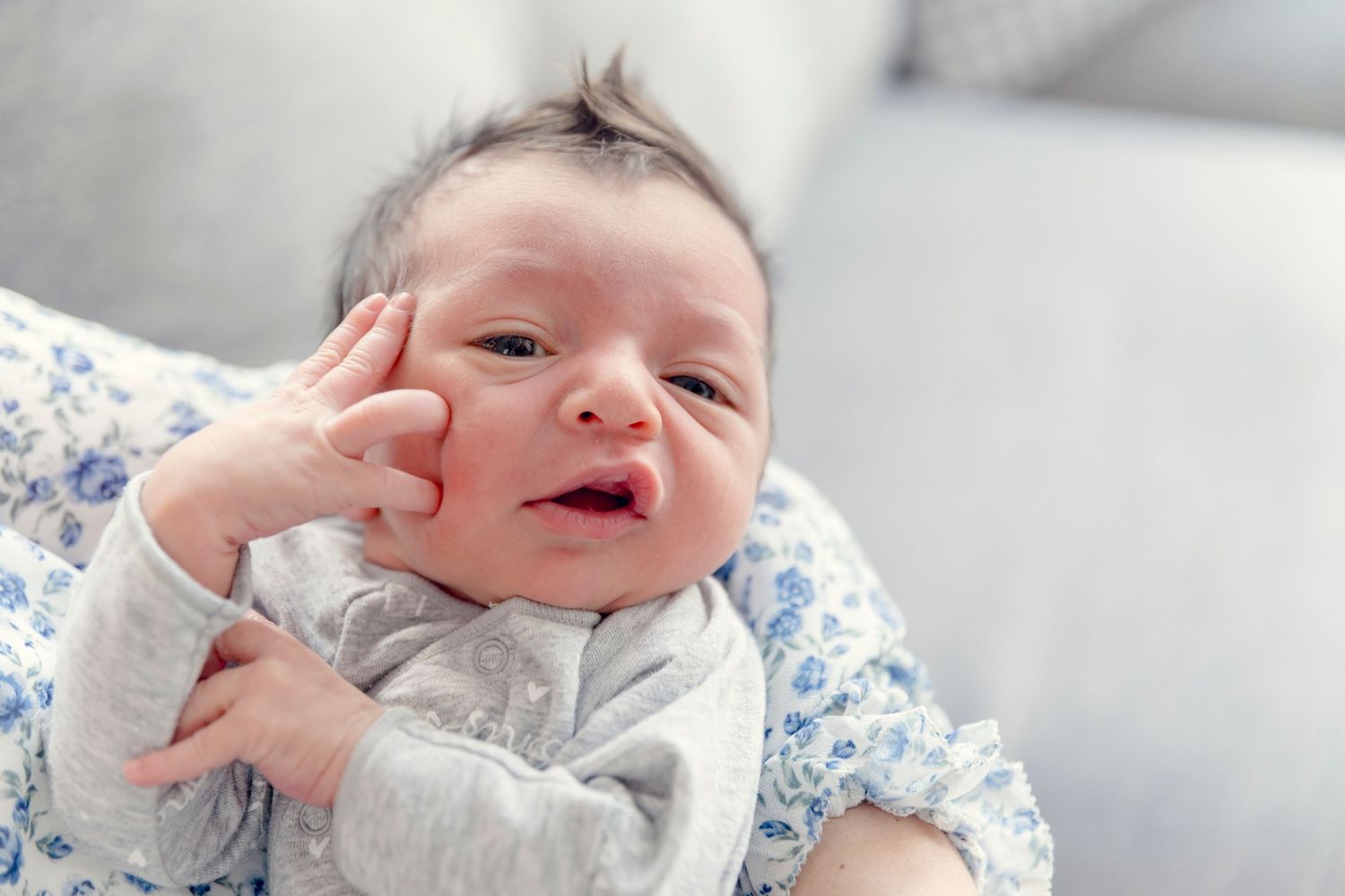 Close-up shots of a tiny newborn baby's face showing various expressions.