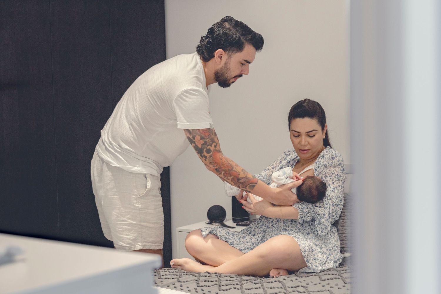 Couple bonding with their newborn baby on a comfortable couch.
