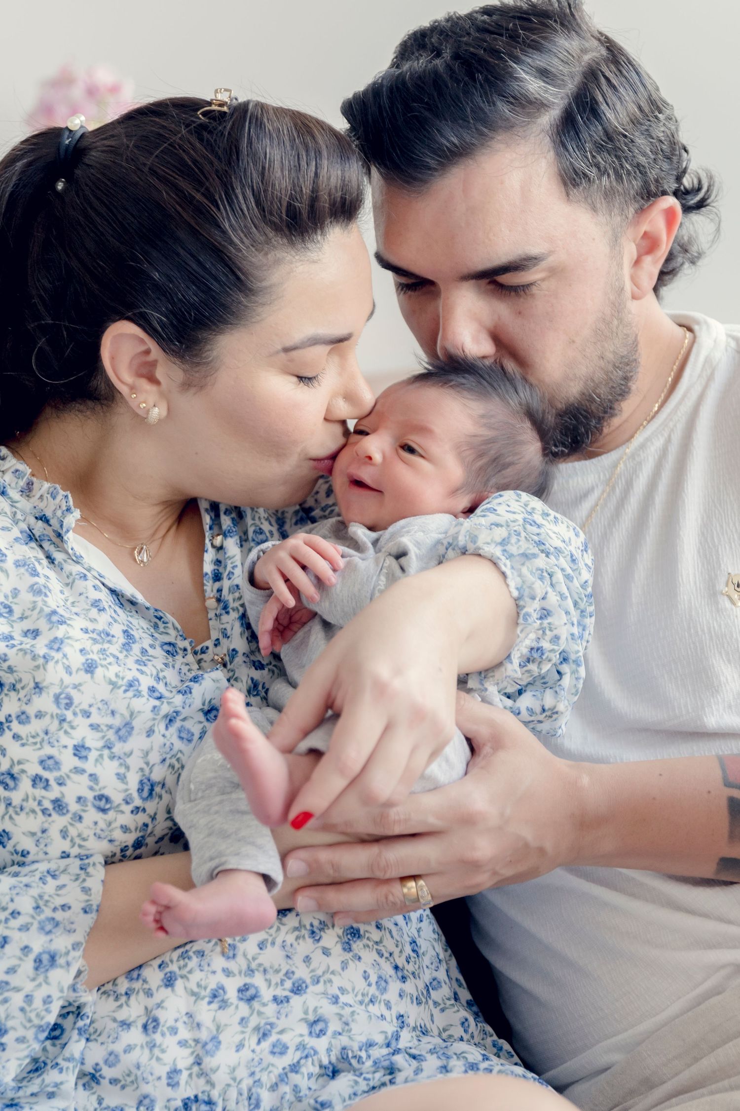 Parents sharing tender moments with their newborn baby in an intimate indoor setting.