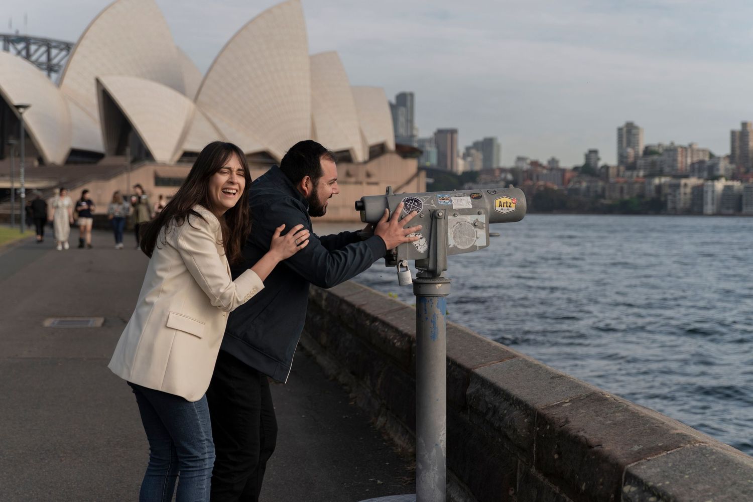 Couple enjoying a romantic moment by Sydney Harbour with Opera House in background.
