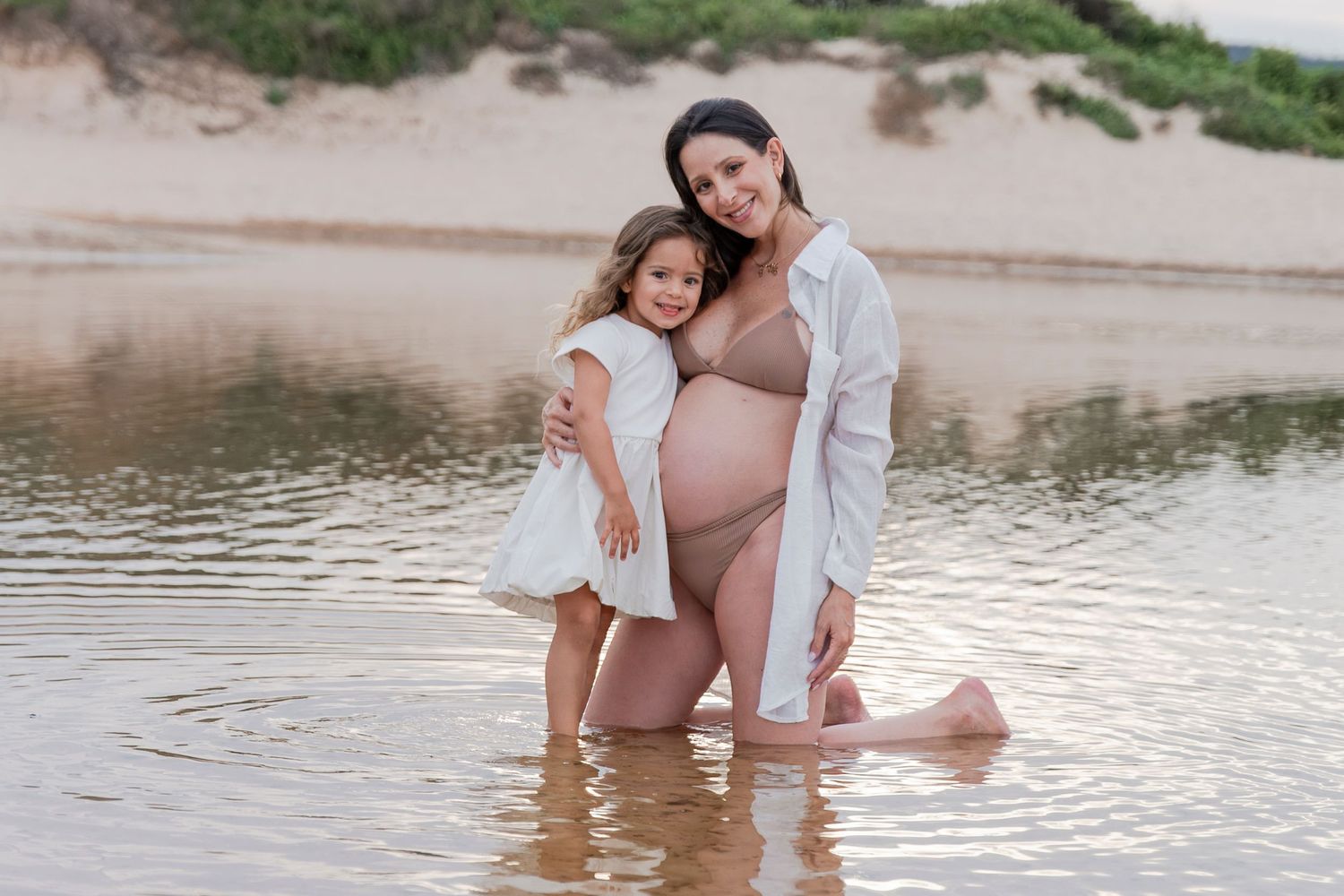 Relaxed family photoshoot by the water during golden hour.