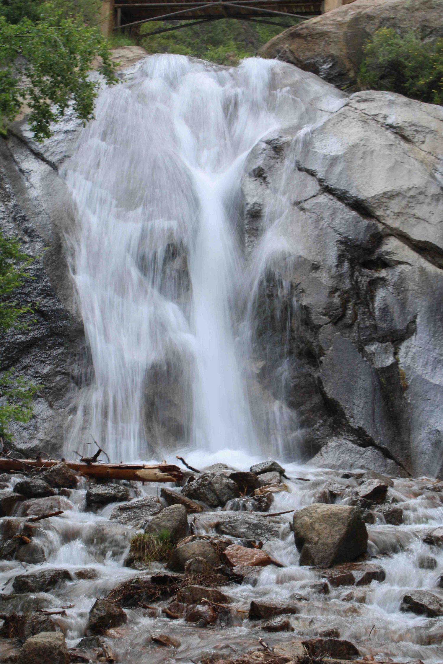 Cascading waterfall tumbles over rocky cliffs creating white spray and rapids.