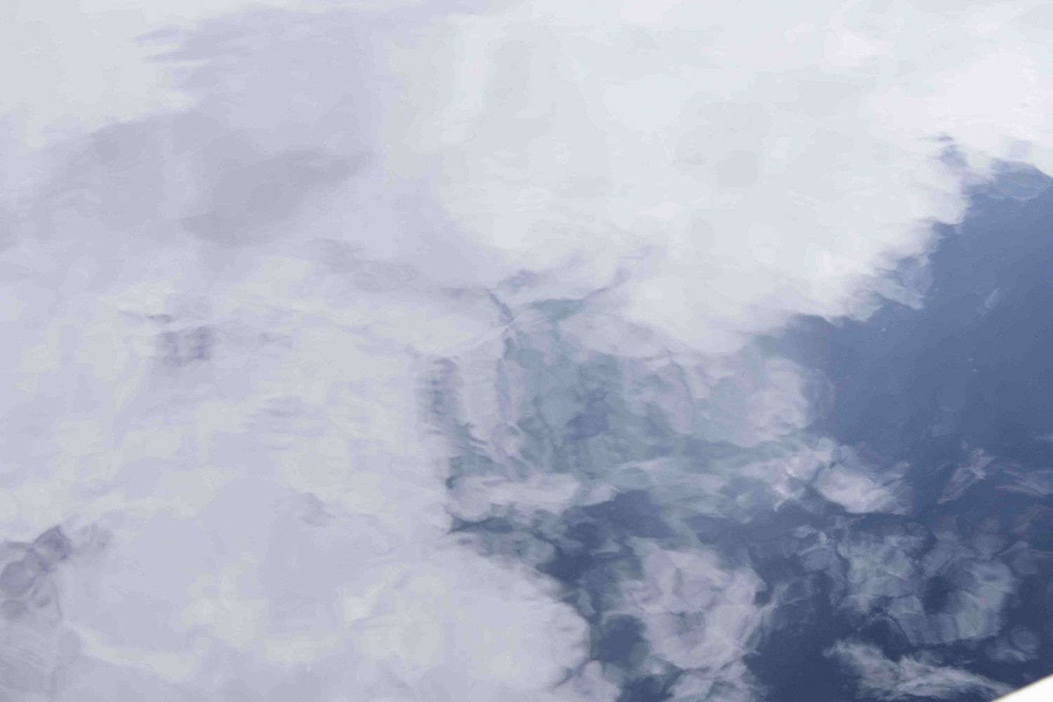 Abstract aerial view of cloud formations against a light background.