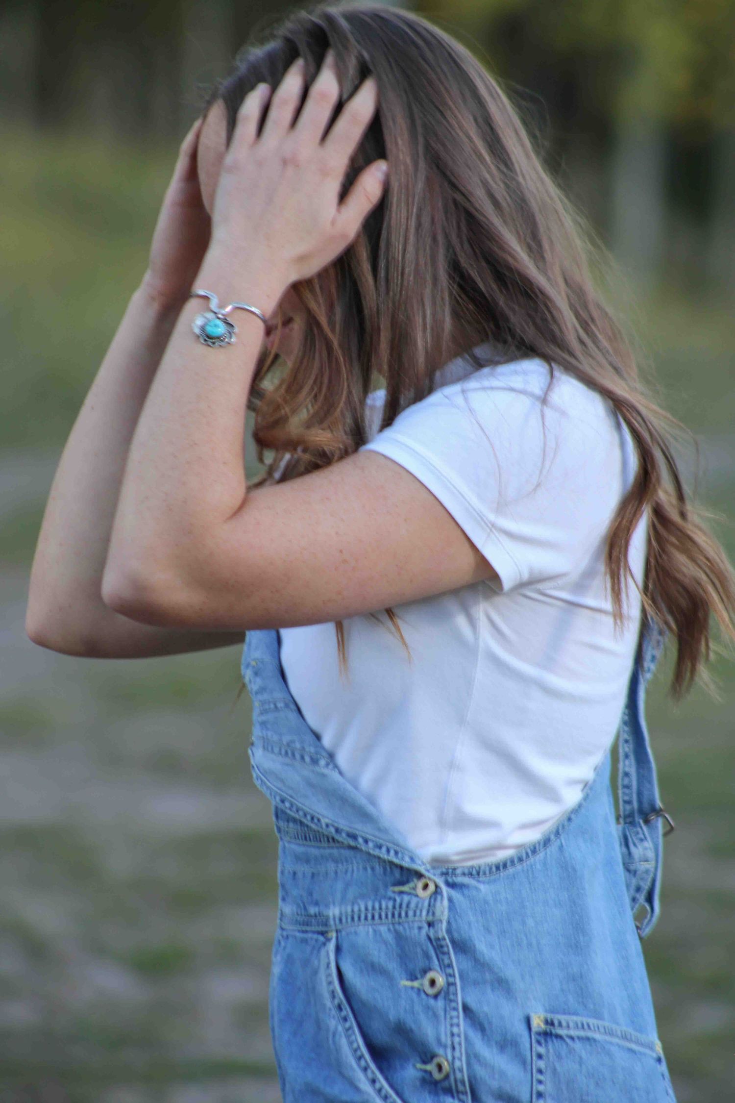 Series of poses with hand gestures showing denim overalls and white t-shirt against blurred background.