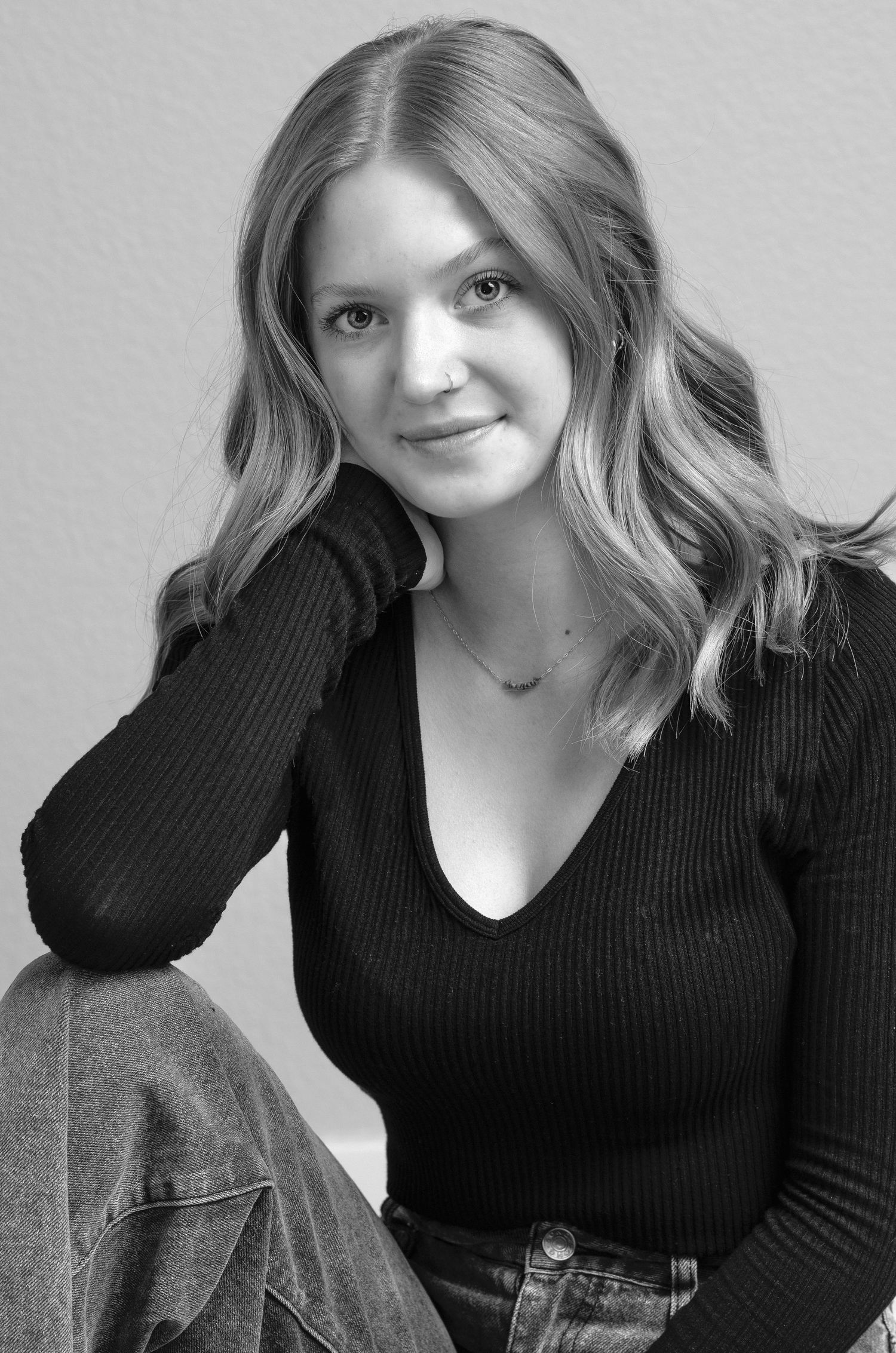 Person wearing black sweater poses in casual monochrome portrait series.