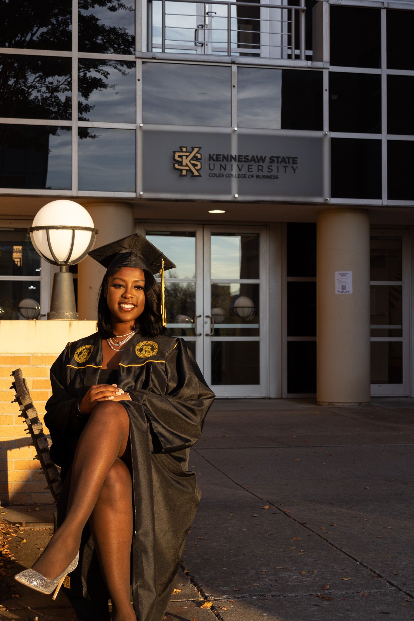 Graduation photo session at Kennesaw State University entrance during golden hour.