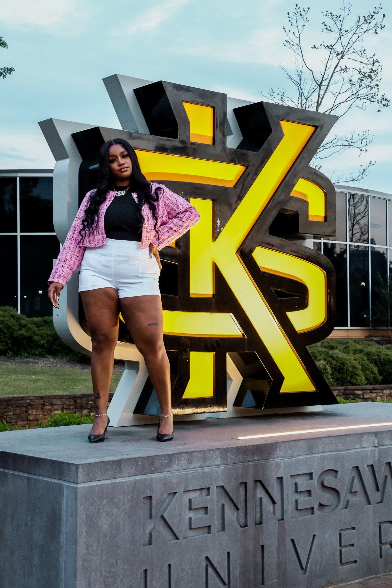 Fashion pose in front of the iconic Kennesaw University logo monument.