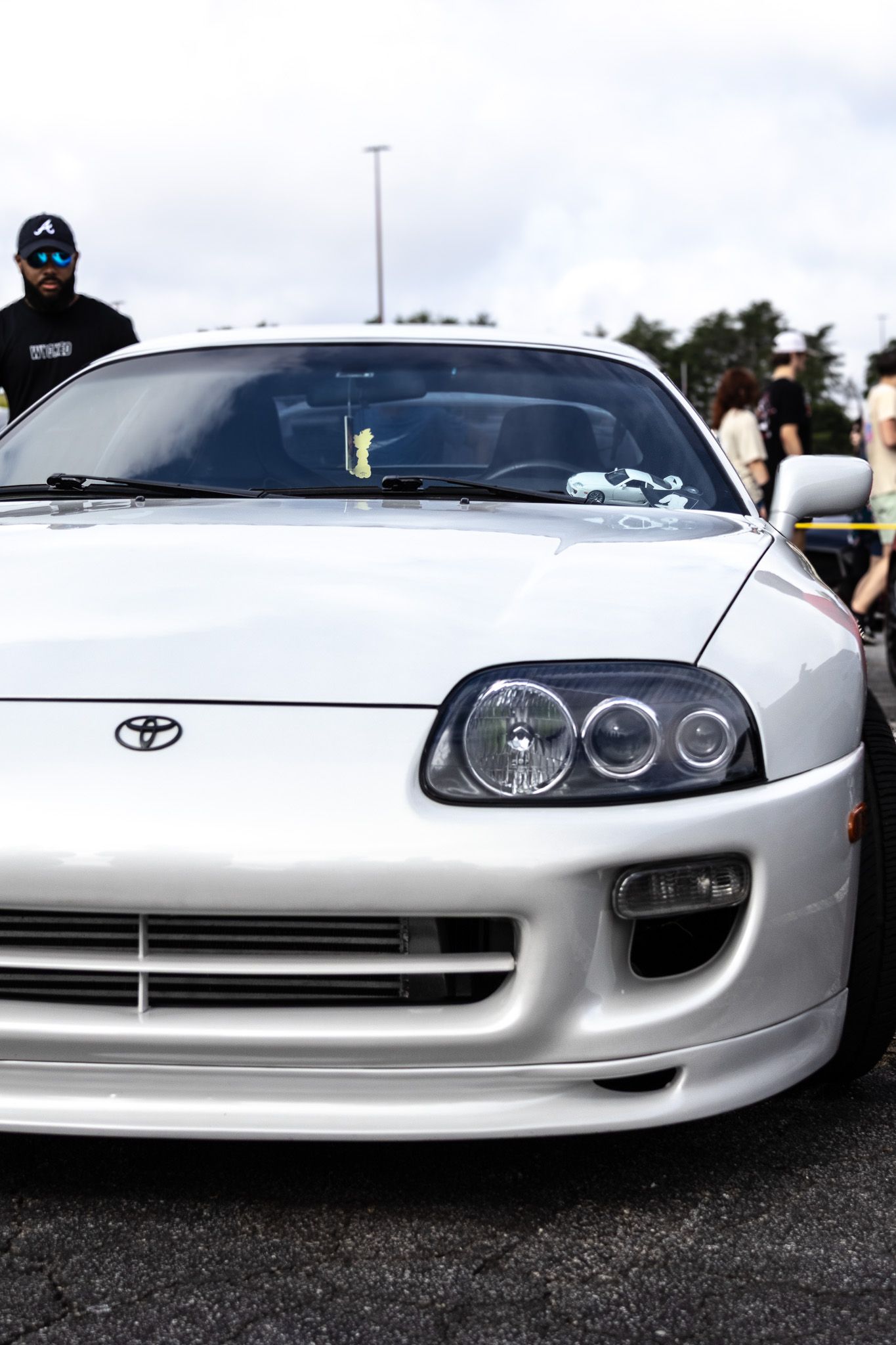 Close up front view of a silver Toyota Supra MK4 with projector headlights.