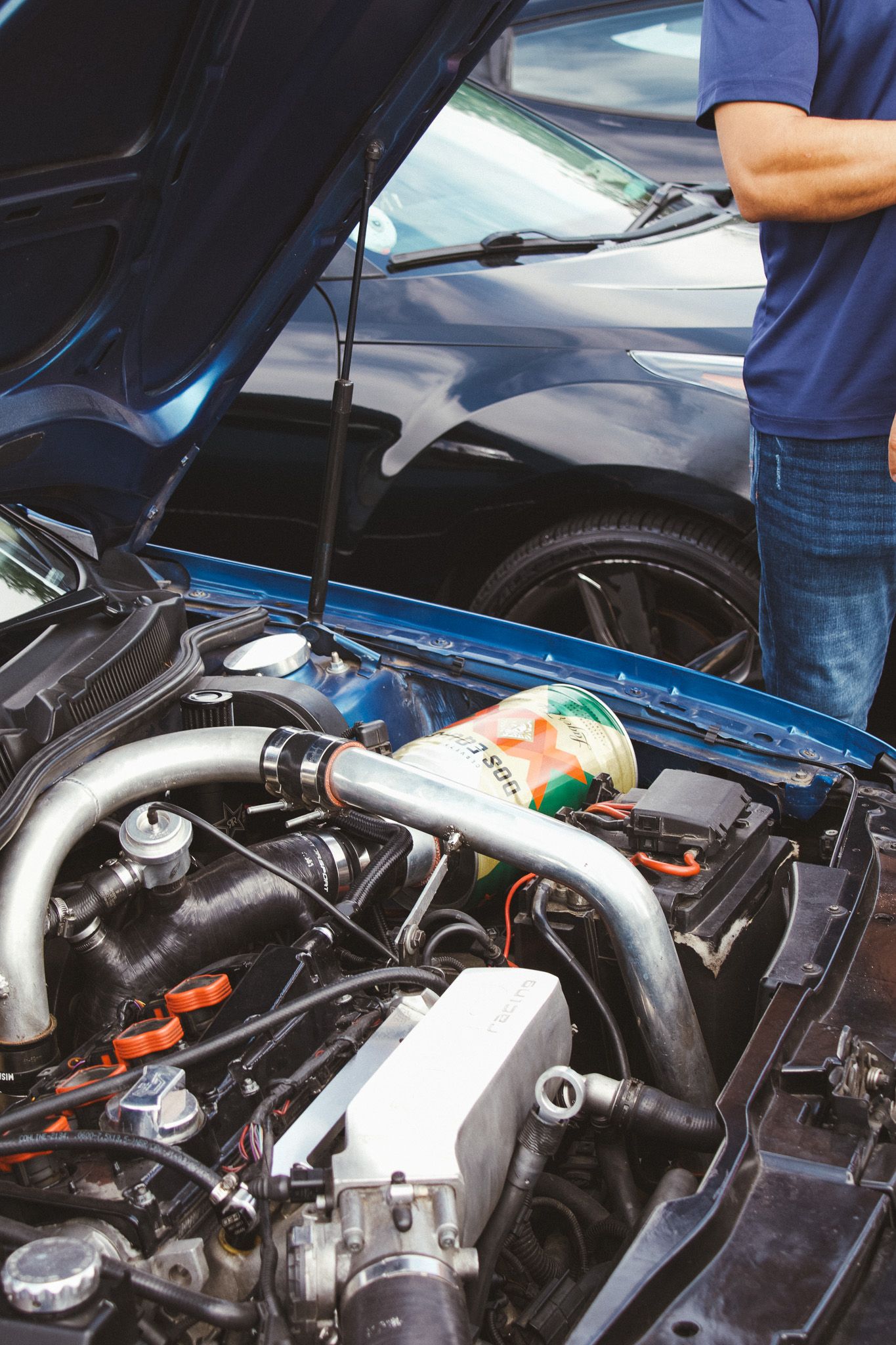 Under the hood view of a modified car engine with aftermarket parts and components.