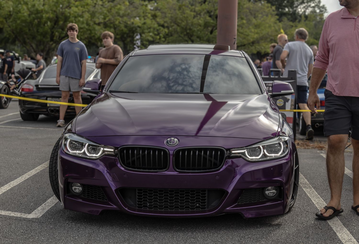Purple BMW M3 with aggressive front styling and glowing angel eyes headlights.