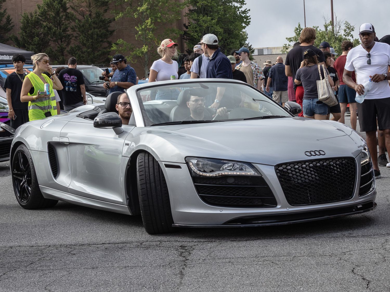 Silver Audi R8 Spyder convertible supercar at a car show event.