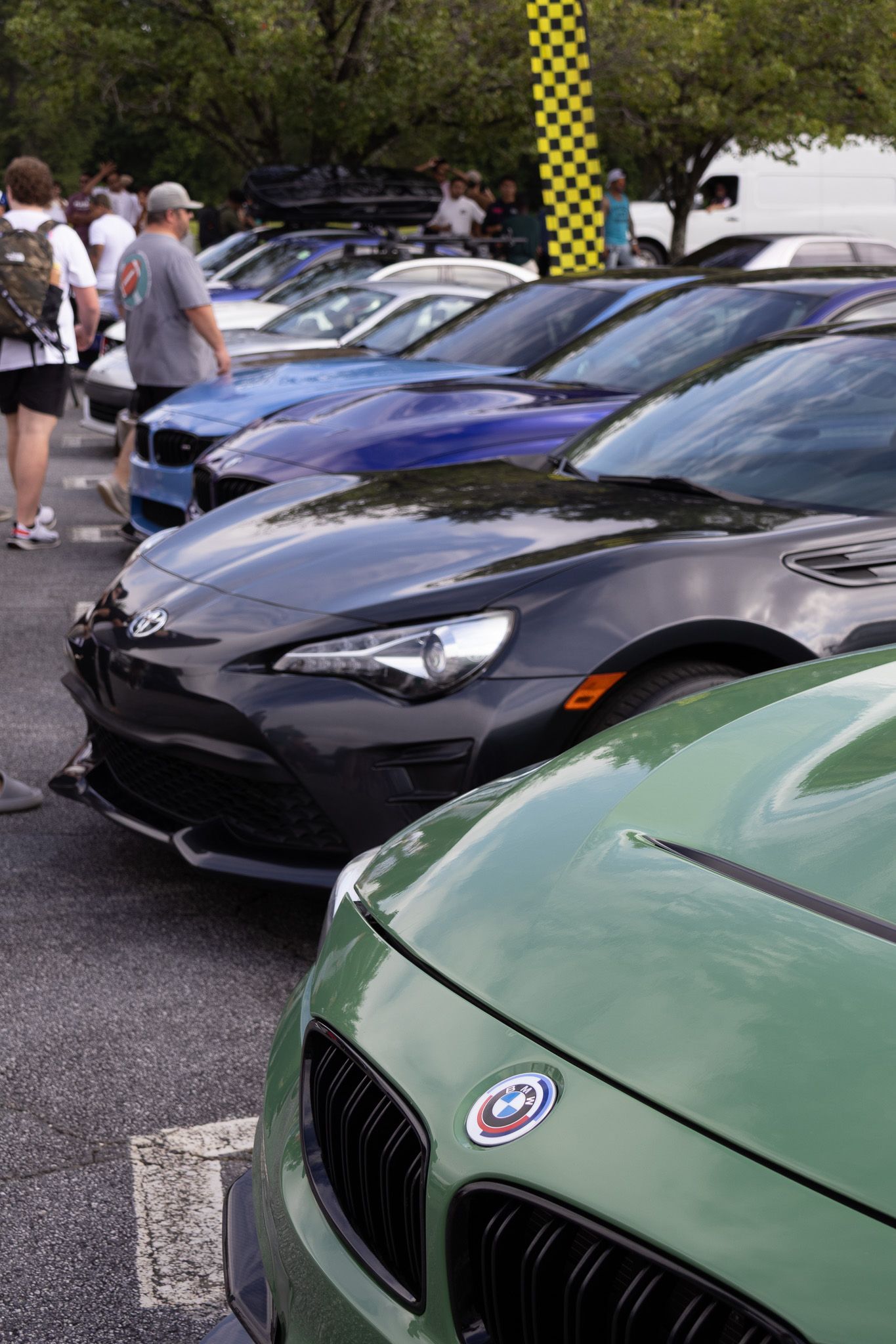 Collection of sports cars including BMW M4 and Toyota 86 at a car show.