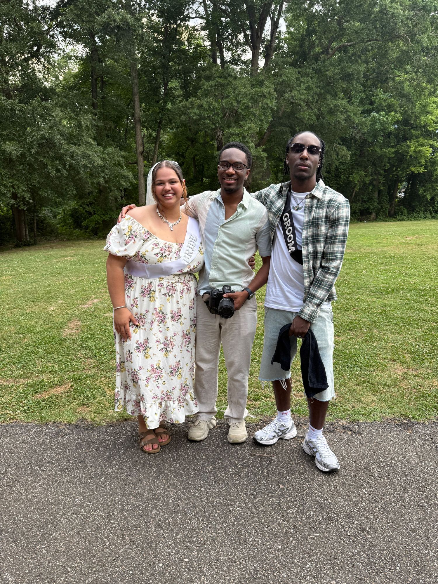Black photographer smiling in picture with just married couple in Richmond Virginia