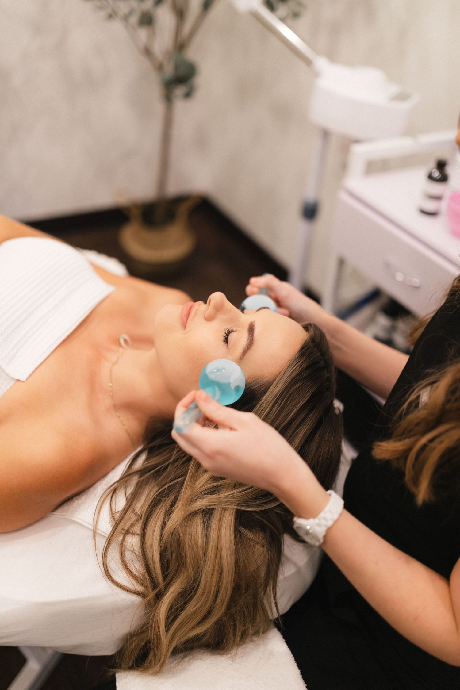 Professional acupuncture treatment being performed on a relaxed client lying on a massage table.