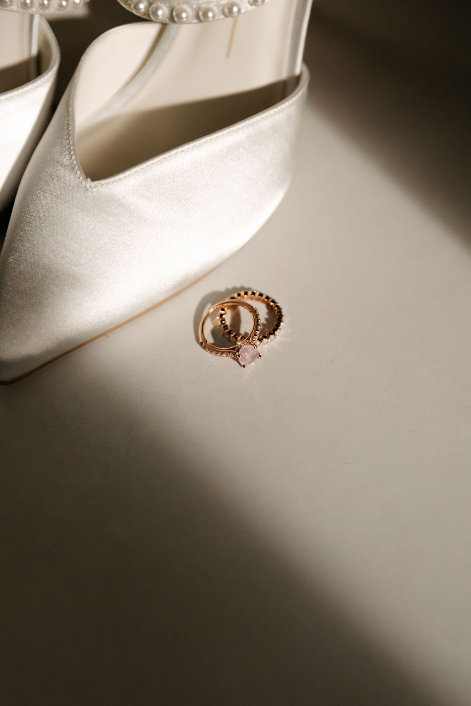 A series of close-up photos showing delicate pearl and gold jewelry pieces arranged on a white surface in dramatic lighting.