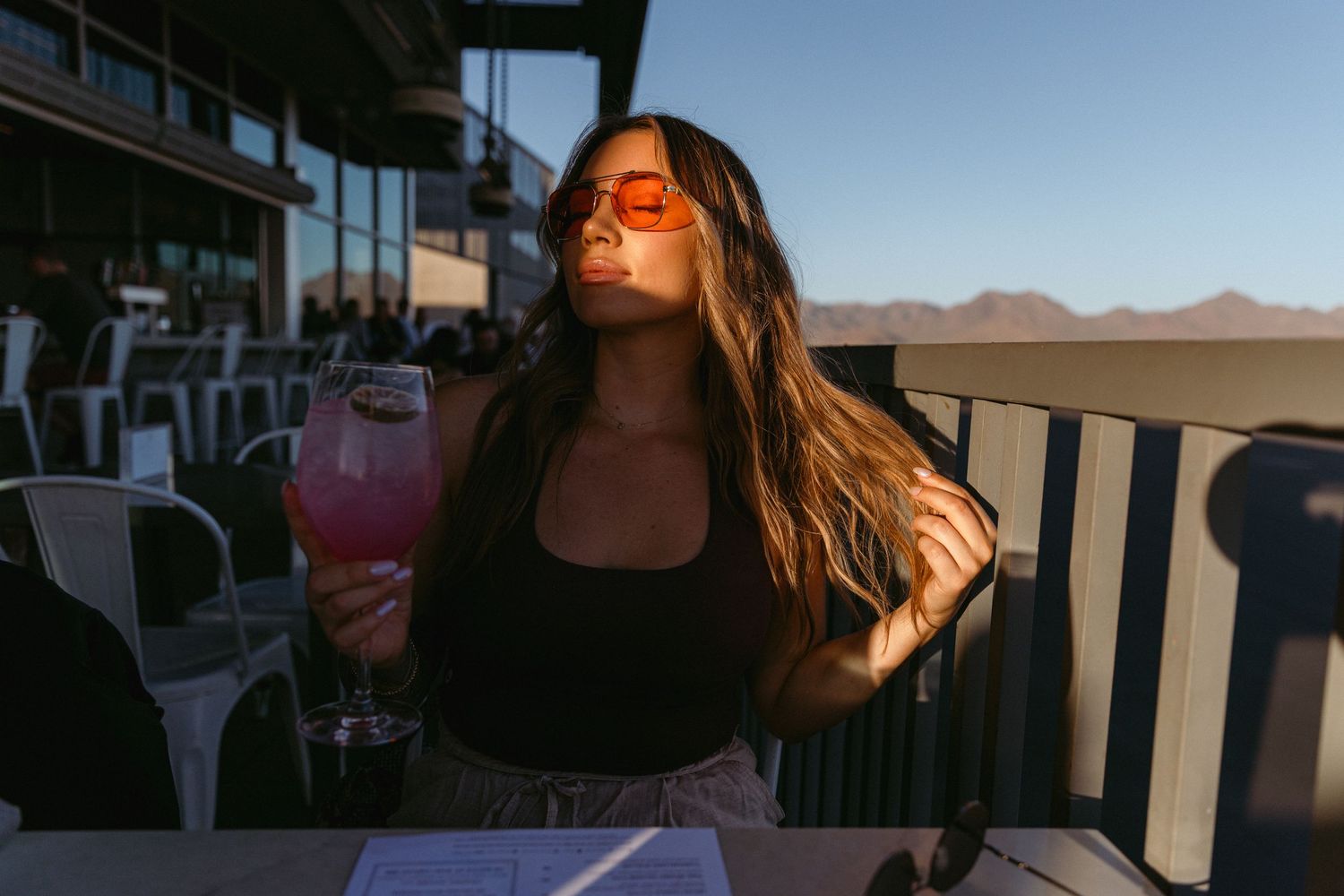 A silhouette enjoying a sunset on an outdoor patio with mountains in the background.
