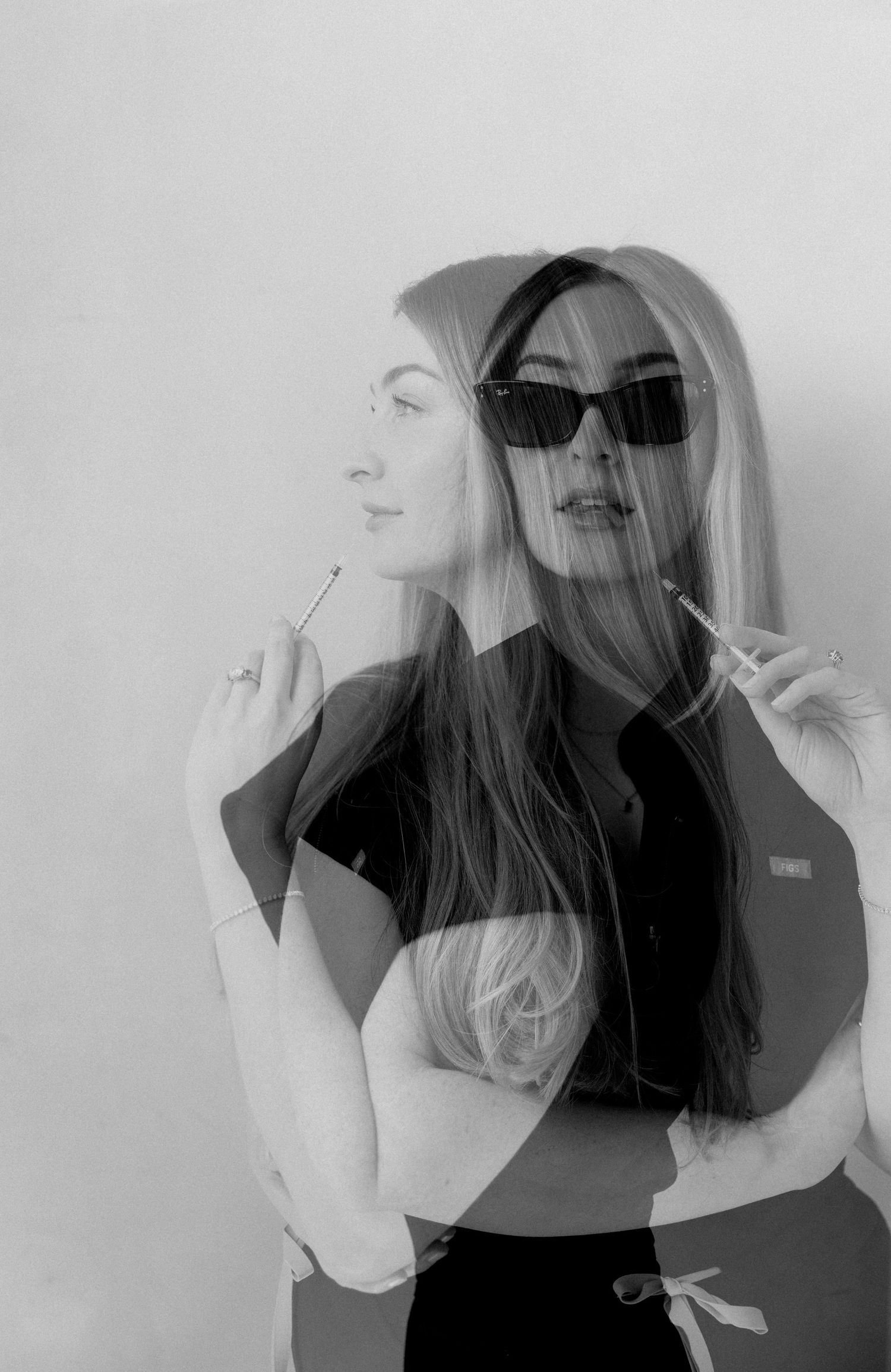 Black and white double exposure portrait of a woman with sunglasses holding a cigarette, artistic photography.