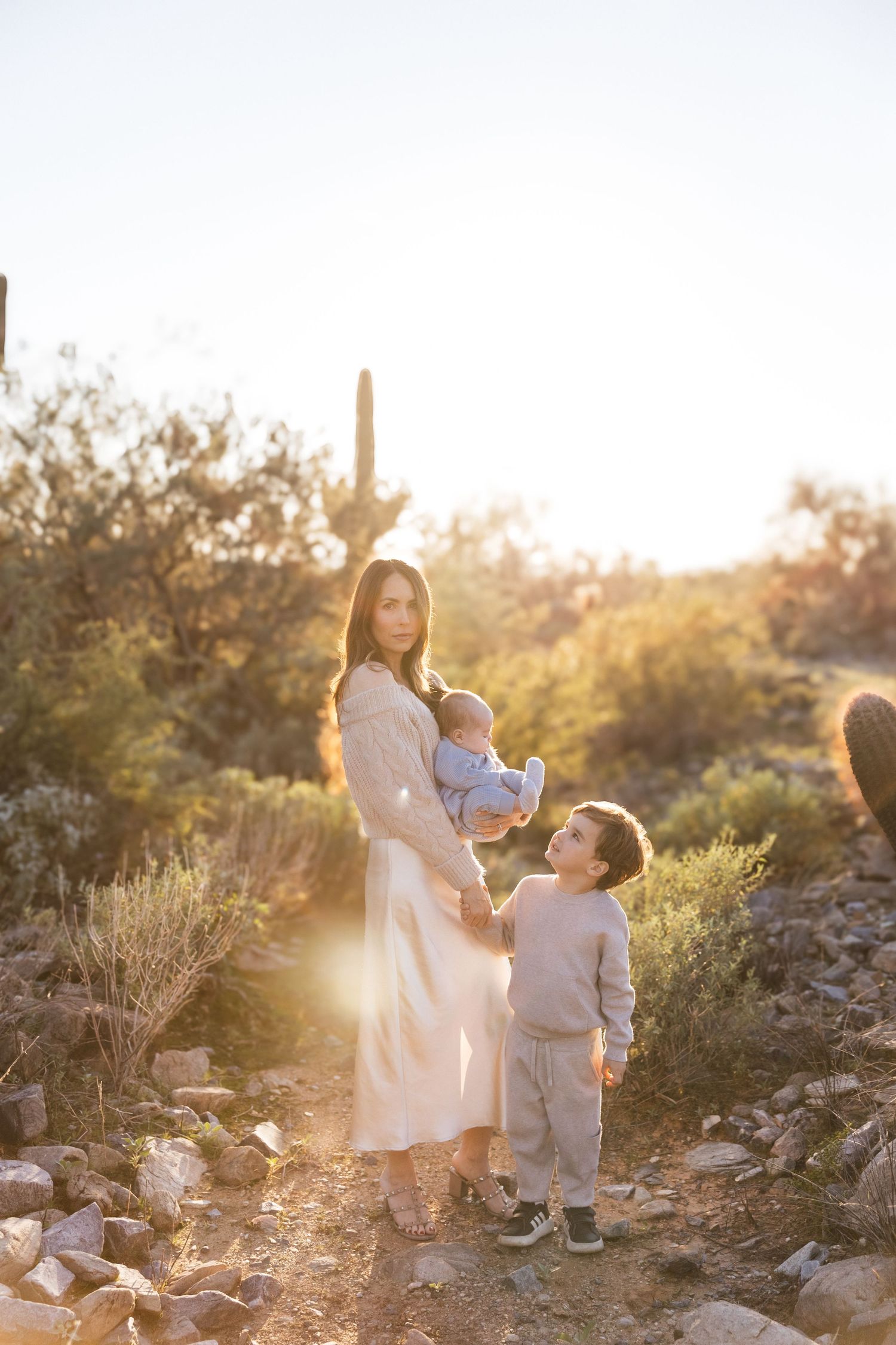 A family portrait at golden hour in the Arizona desert with saguaro cacti and desert brush.