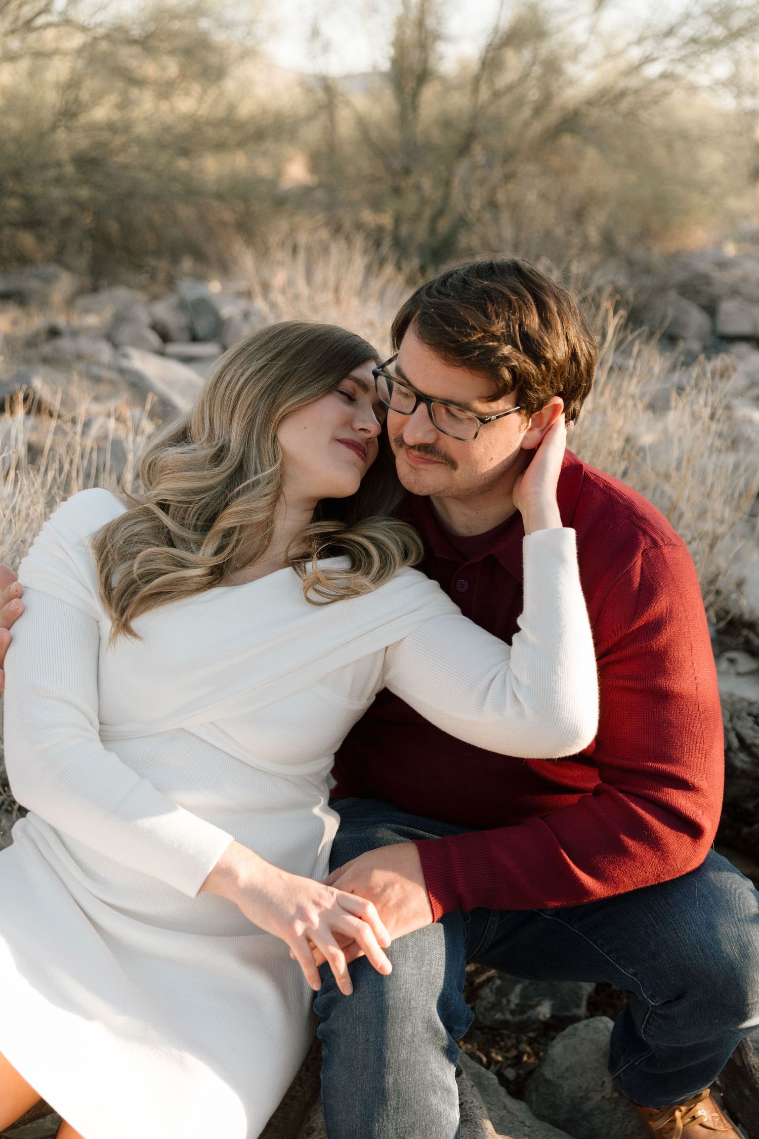 Intimate moment captured on desert rocks during engagement session.